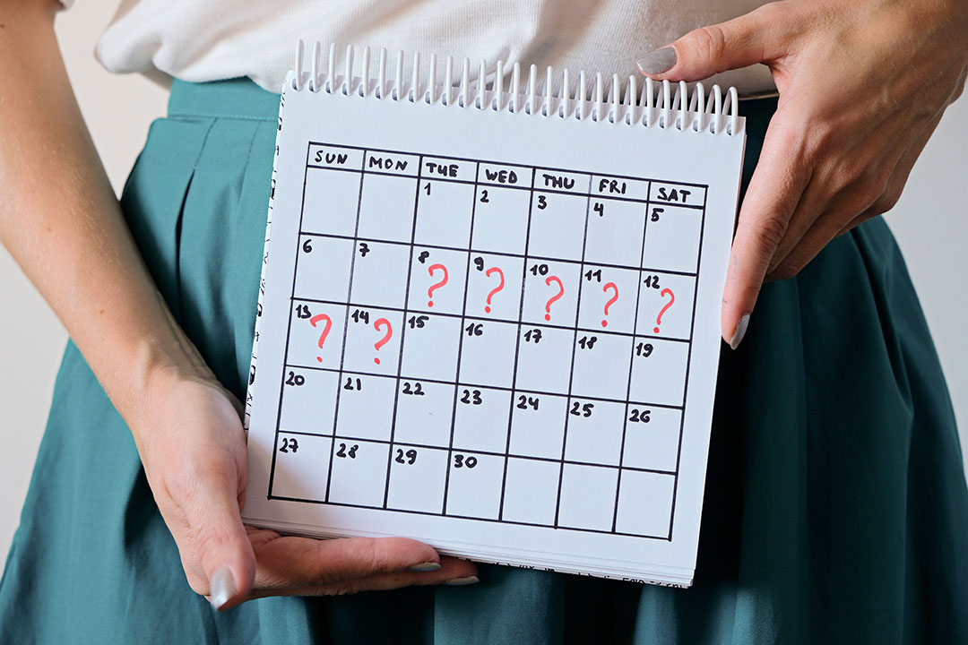 Woman holding calender with marked missed period.