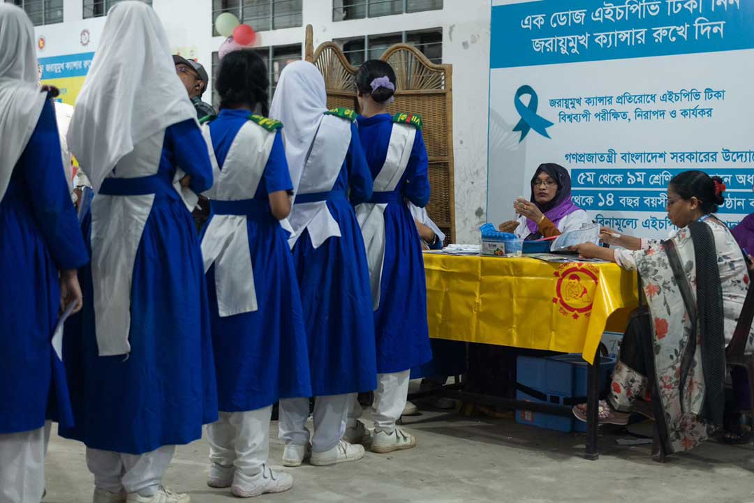 Schoolgirls line up for vaccination.