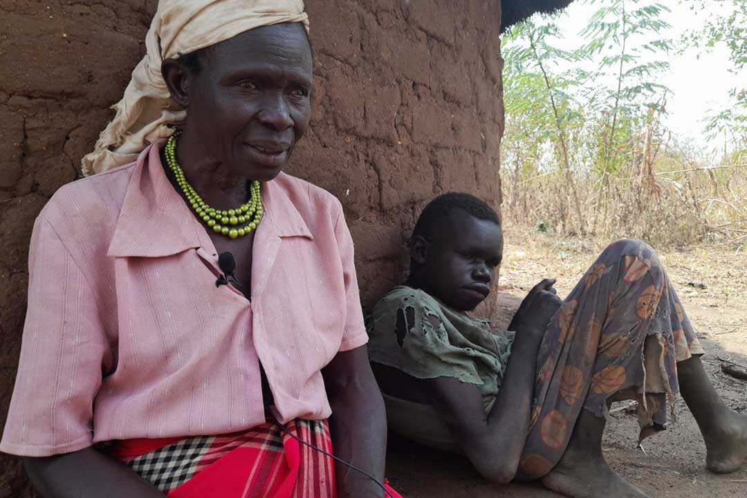 Ventorina Aculu of northern Uganda sits next to her adult son, Omac Alfred, who has a rare neurological disease known as nodding syndrome. Credit: Pat Robert Larubi