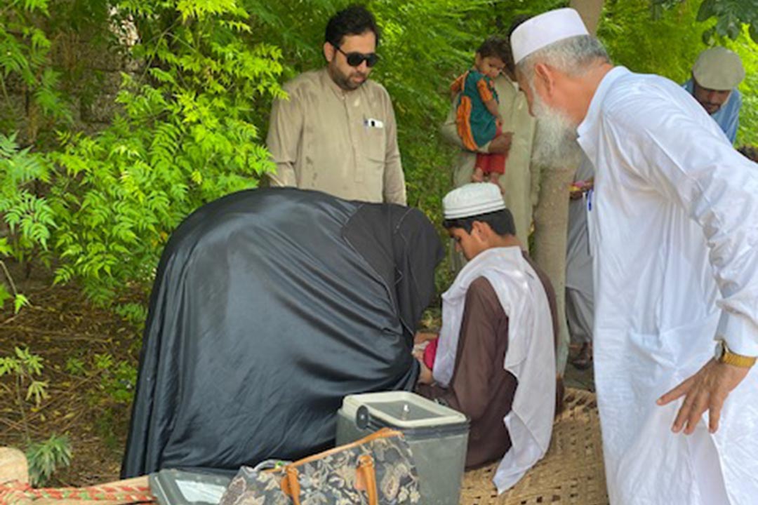 Female vaccinator from DistricT Health Office Team in Bannu giving EPI card after vaccinating a zero dose child. during RUR-1. Credit: Huma Khawar