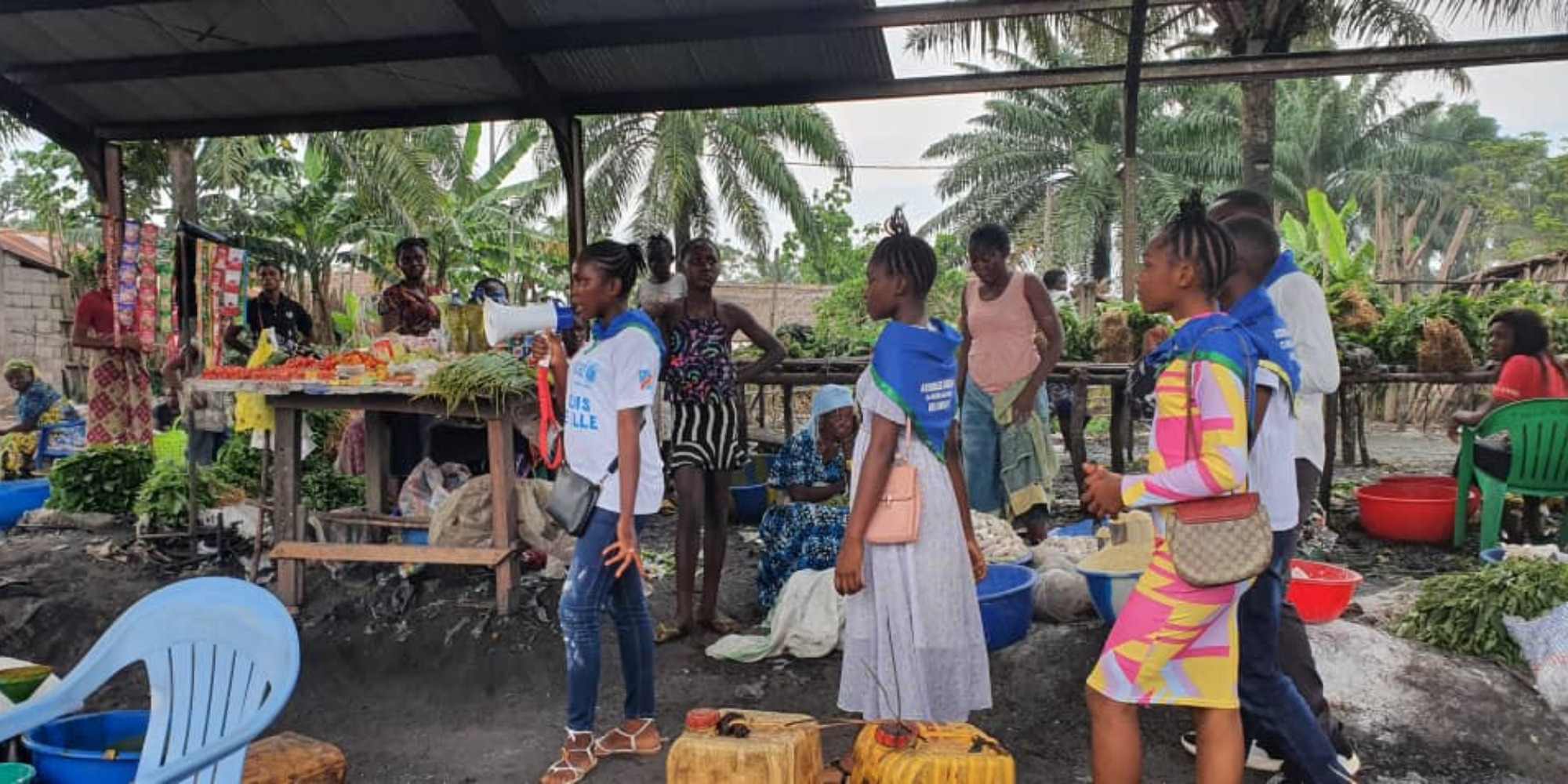 Dans le cadre du plan Mashako, les jeunes membres du Club urbain des enfants sensibilisent les parents à la vaccination de routine, sur un petit marché de la ville de Mbandaka. Crédit : Vanessa Mimisanga