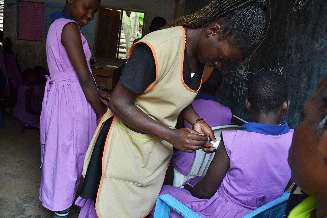 Mercy Nyakecho, a nurse at NAWEC, vaccinating girls at Bright Valley Walukuba Primary School