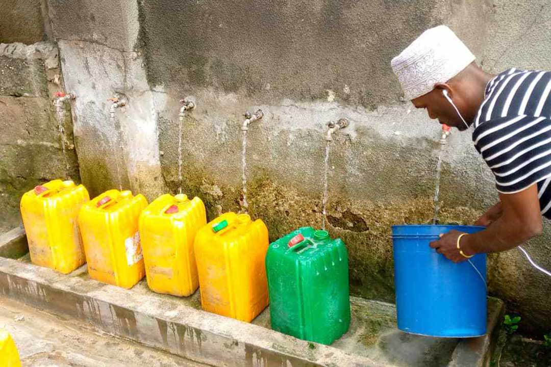 A resident of Kijangwani in Zanzibar fetches clean water from public taps for home use. Credit: Syriacus Buguzi