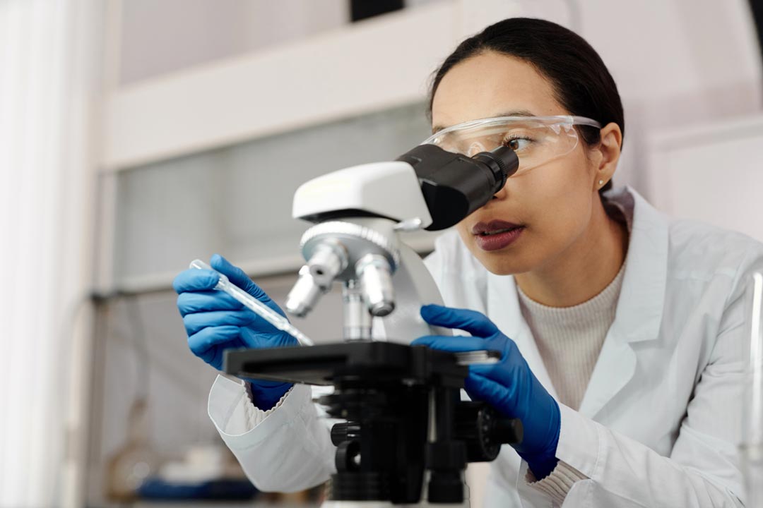 Woman using a microscope. Credit: Edward Jenner on Pexels