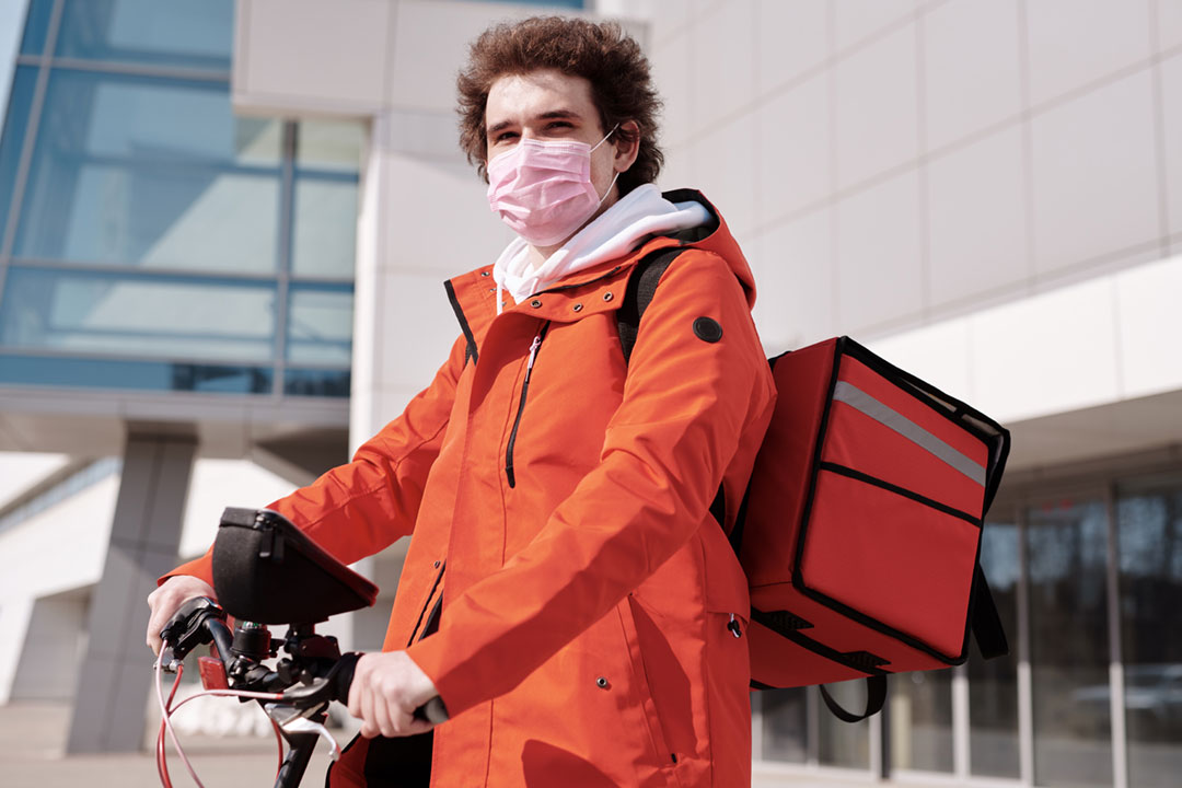 A man with a bike wearing a face mask. Credit: Norma Mortenson on Pexels