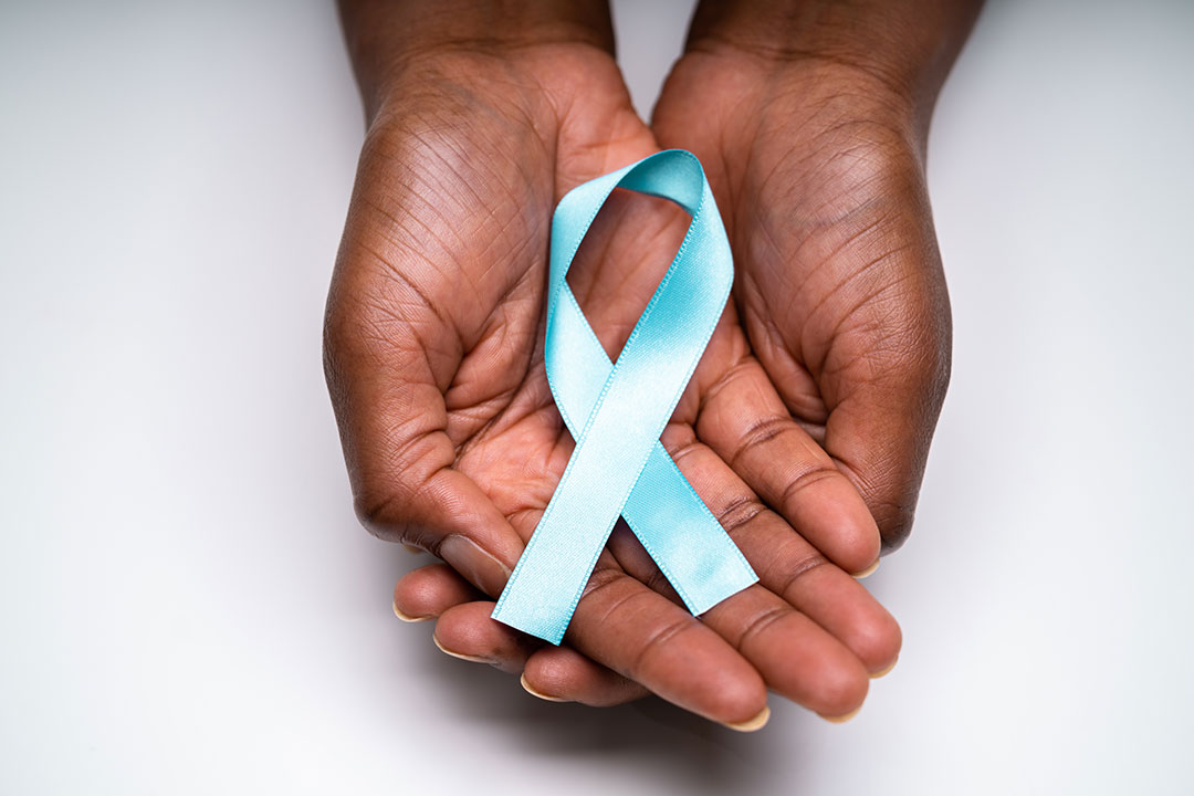 Human hands holding teal ribbon to support cervical cancer awareness