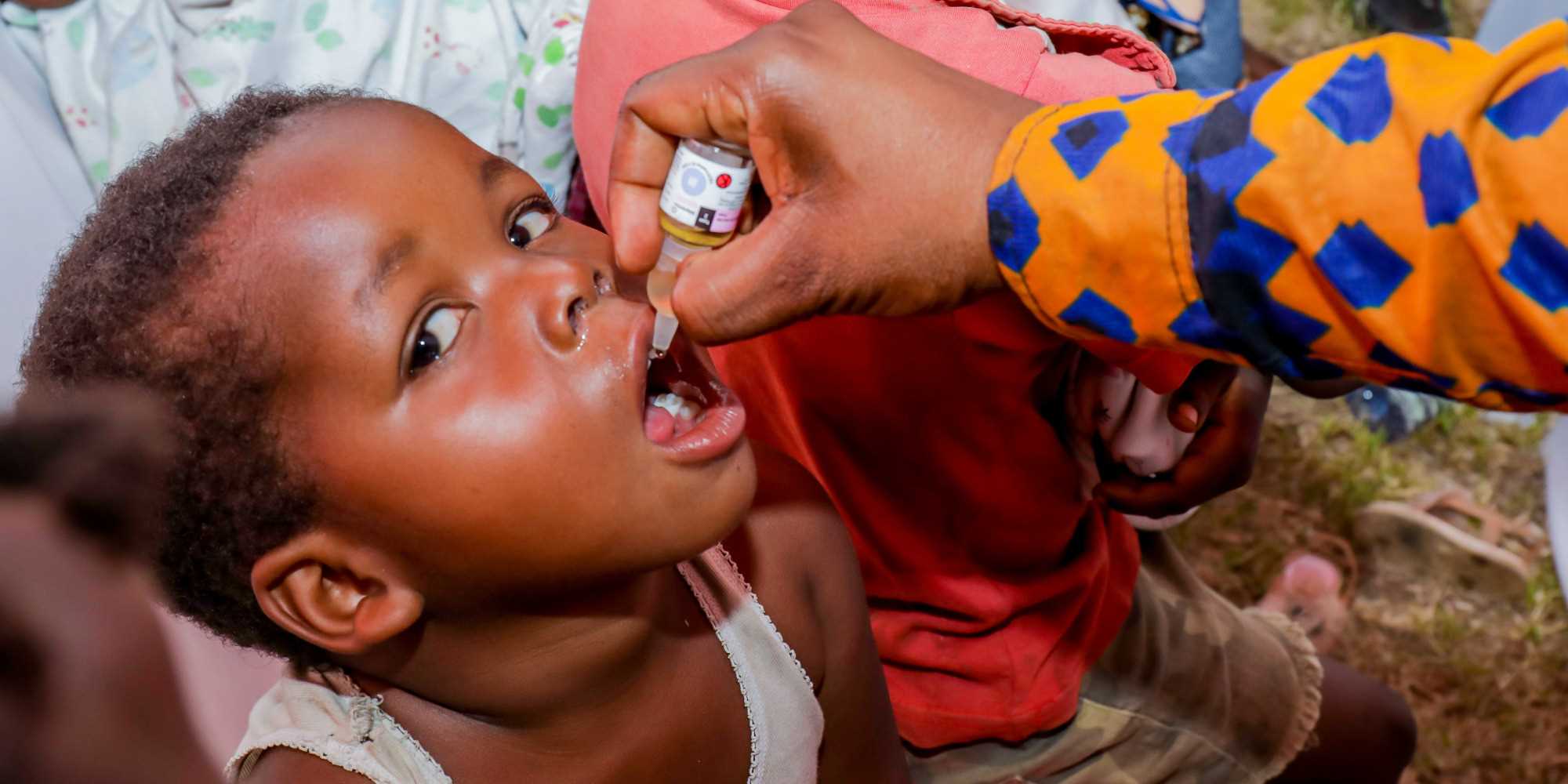 Un enfant recevant un vaccin oral contre la polio, administré par un agent de santé communautaire. Crédit : Diane Ndonse