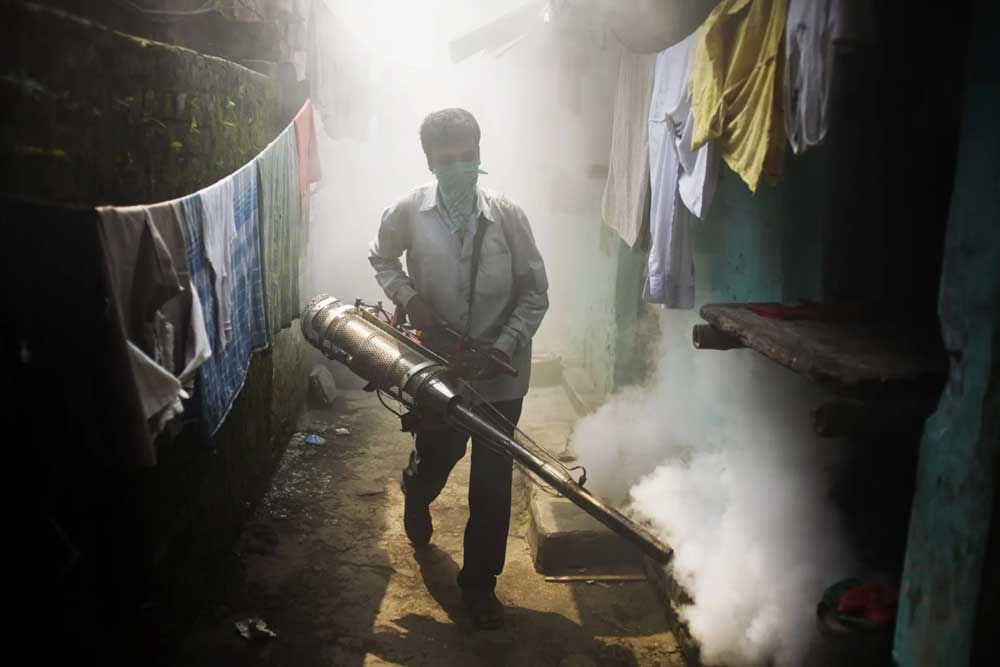 Man spraying an alley with anti-mosquito solution.