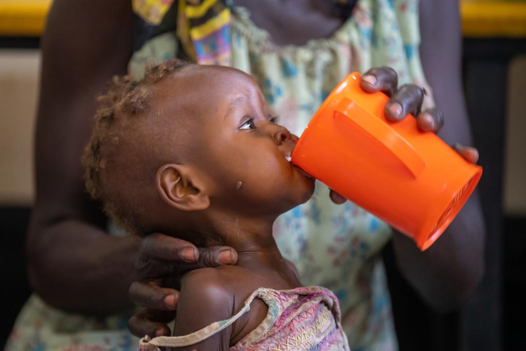 Malnourished infants are coaxed to drink a high-calorie formula in the malnutrition ward. Credit: Larry C. Price