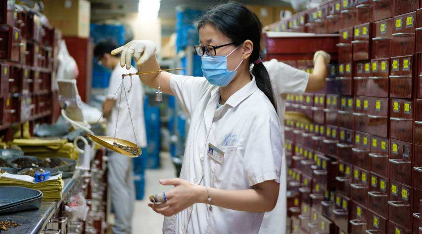 A pharmacist mixing traditional Chinese medicine at Jiangsu Chinese Medical Hospital in Nanjing, China. Photo by Kristoffer Trolle (CC BY 2.0)