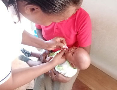 Harriet Ngugi administers a dose of the oral rotavirus vaccine to an infant. Credit: Harriet Ngugi