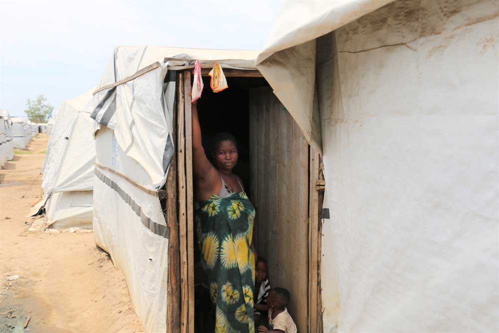 A 22 year old mother of 4, Irakoze Chanceline while standing outside her temporary tent at a makeshift camp in Gatumba, Bujumbura.