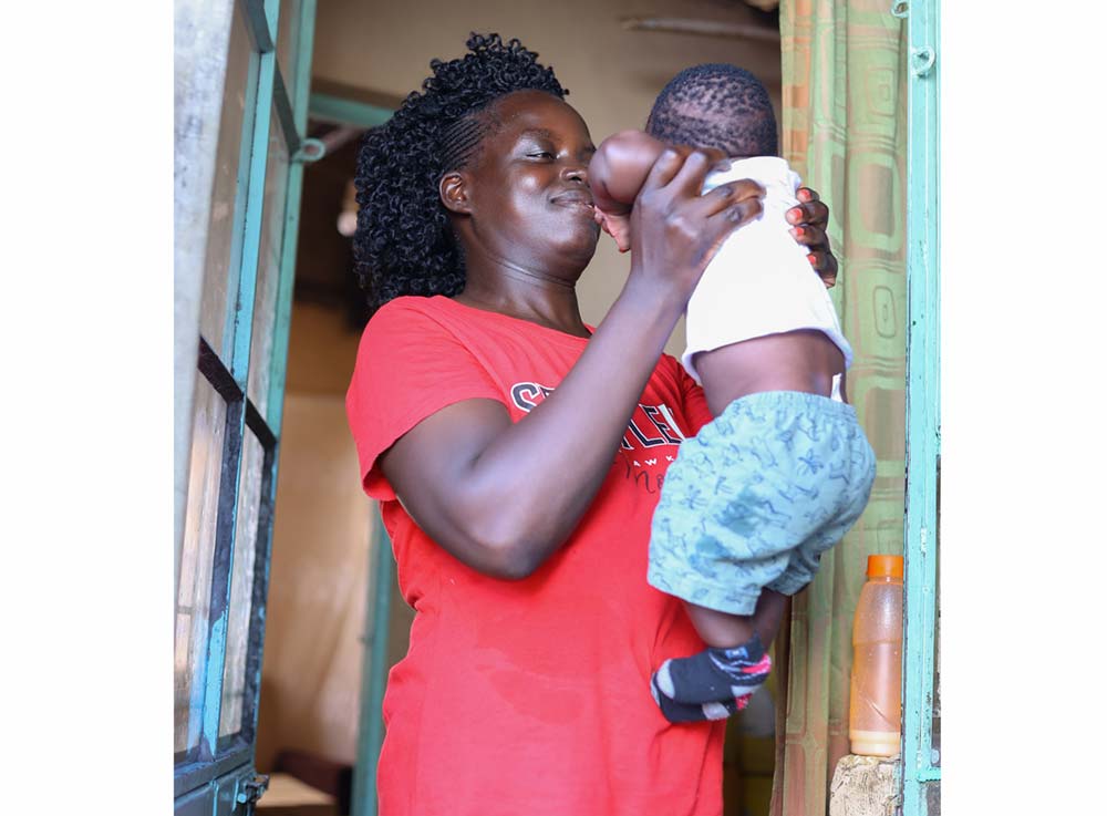 Ms Grace Achieng holds her baby David Shammer during an interview at her home in Ahero, Kenya. Credit: Angeline Anyango.