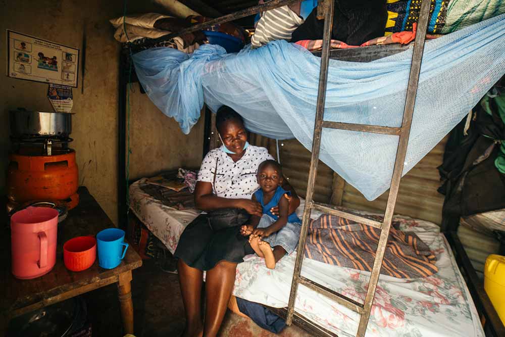 Everleen Awino Nyapola, a Nyalenda B resident, with one of her four children in their bedroom. Credit: Kang-Chun Cheng