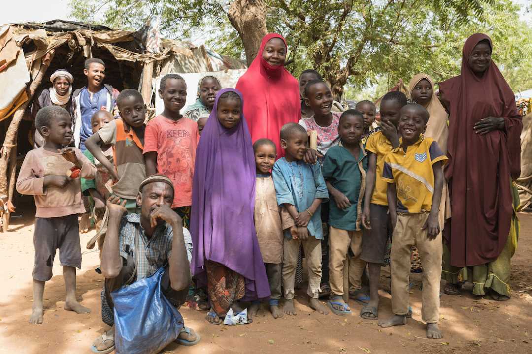 Rachida Moussa (in red), a community health worker in Niamey, Niger, pictured with children living in one of the communities she visits regularly.