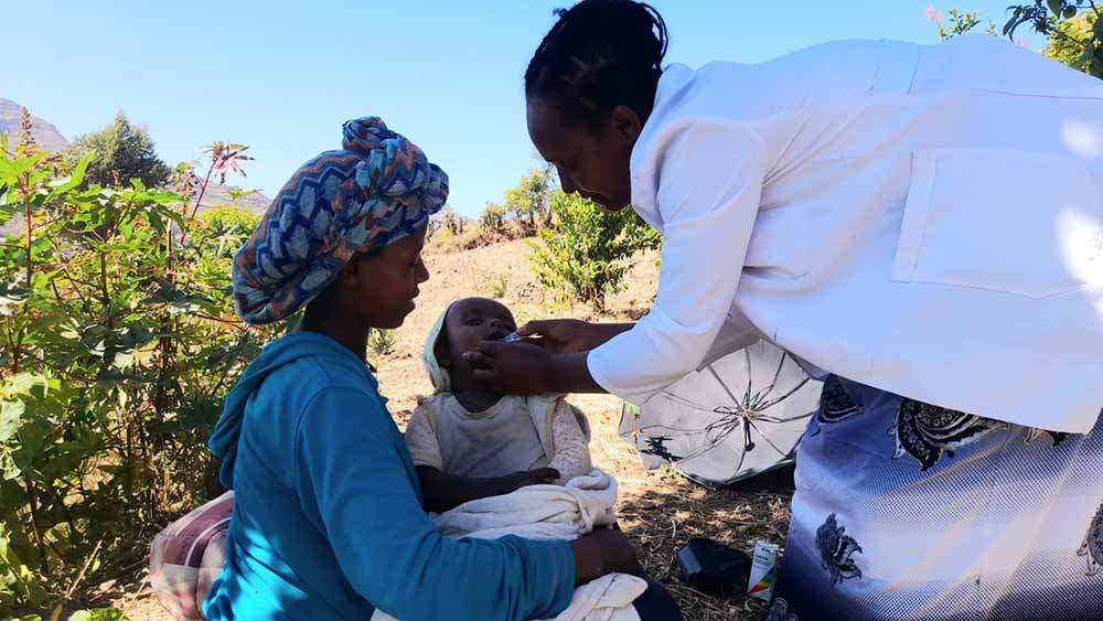 Meseret, the healthcare worker, administers oral vaccine to a child in remotest village in Ambassel district. Credit: Solomon Yimer