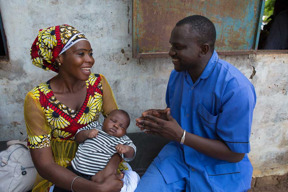 Baboucarr Sarr, community health nurse and midwife, talking to a young mother at an outreach immunisation session in Nioro-Jataba, The Gambia. Credit: Gavi/2018/Guido Dingemans