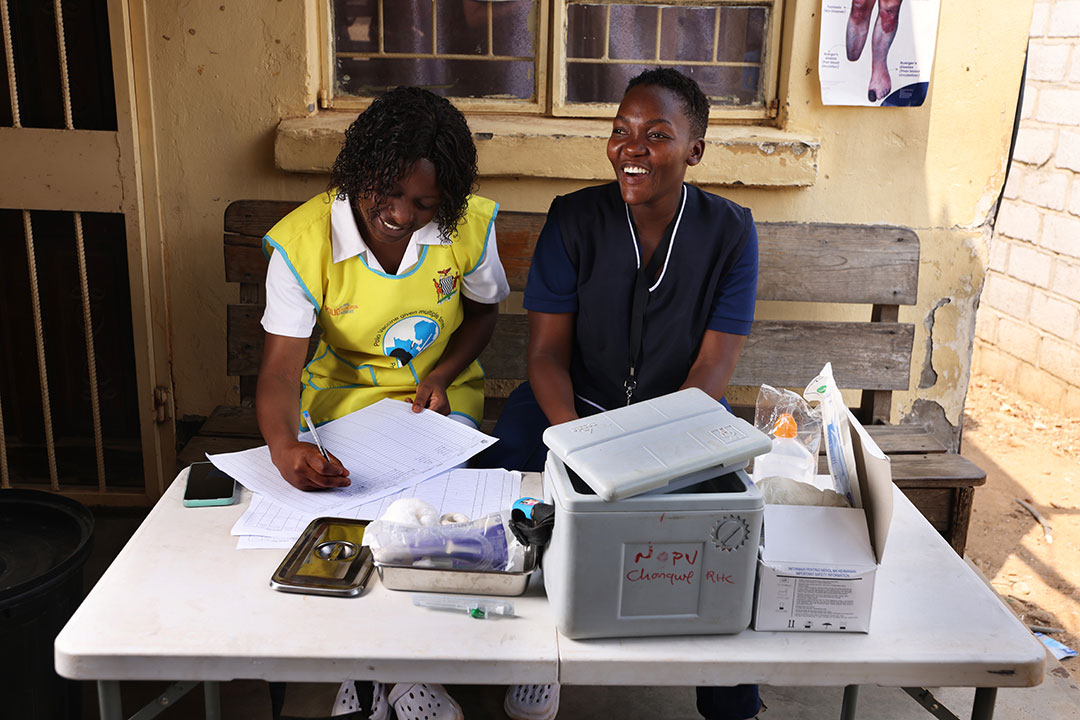 Josephine Mudenda (derecha) es enfermera en el Centro de Salud Rural de Chongwe (RHC) en Lusaka, Zambia.  Se anima a las niñas a recibir la vacuna contra el VPH para prevenir el cáncer de cuello uterino.  Crédito: Jaffe/2023/Peter Kates