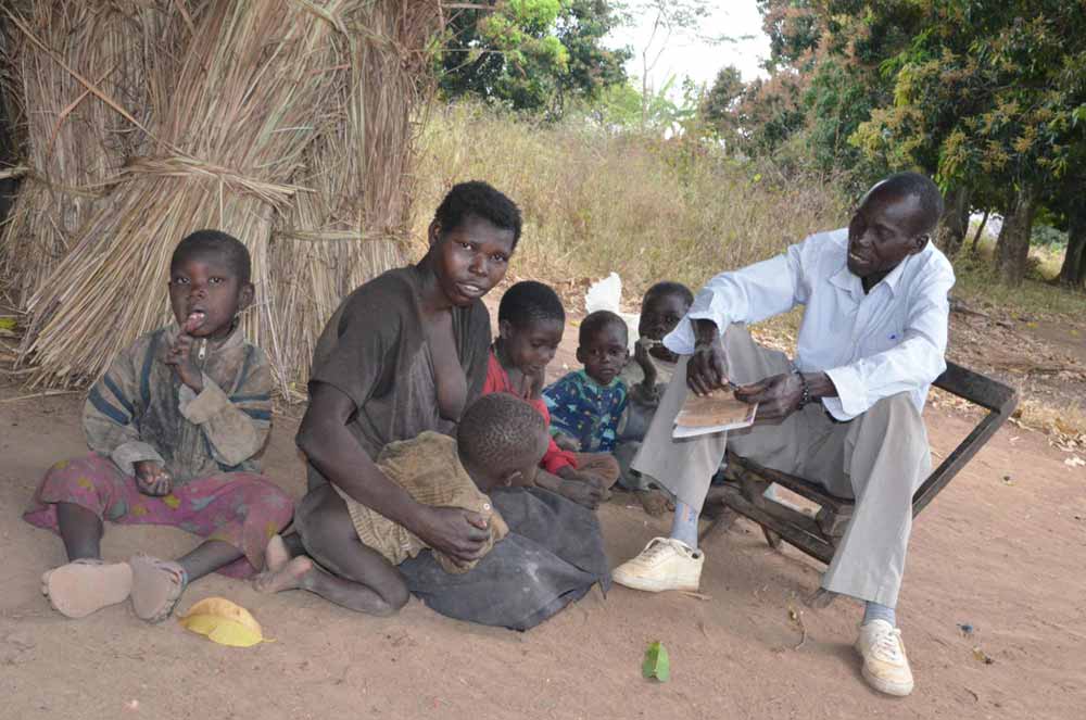 Togero (right) and his adult daughter Apio Rosalva (left) who has nodding syndrome. Rosalva has two children of her own — one to her left and another on her lap. Togero says that with nodding syndrome, very little has been resolved. Credit: Pat Robert Larubi