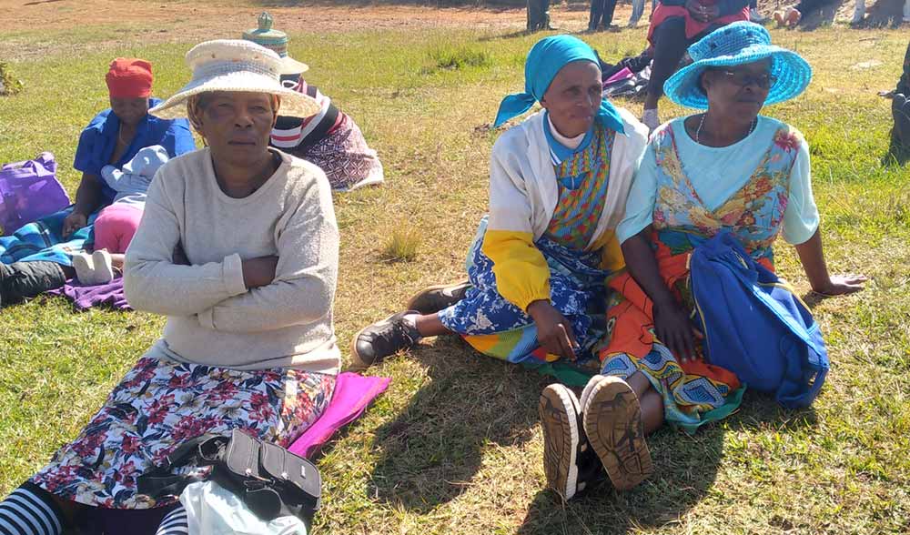 'Masalome Rasetina, middle, attentively follows discussions at the Ha Jimisi measles drive. Credit: Pascalinah Kabi