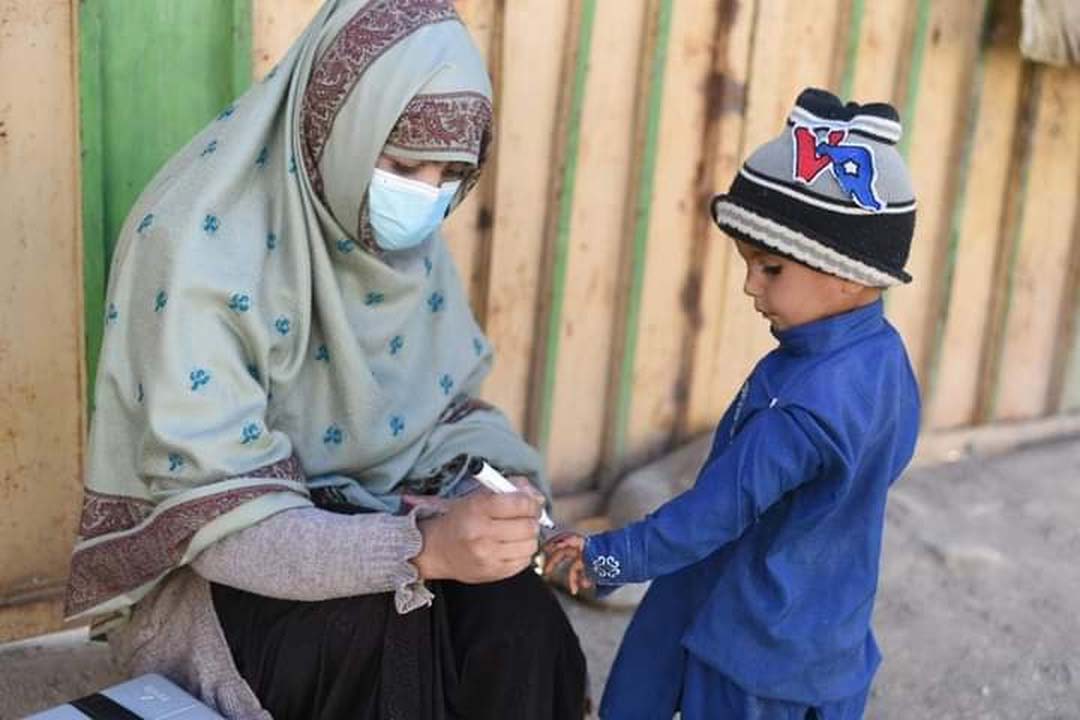 A female polio worker and Amina colleague is vaccinating a kid in Matli. Credit: Saadeqa Khan