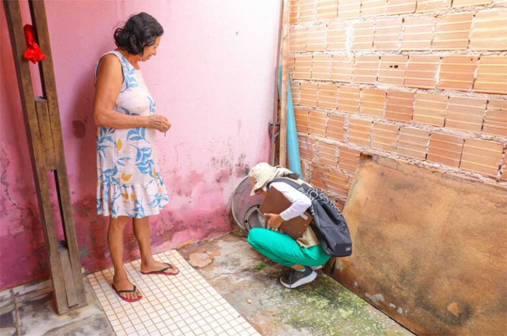 A public environmental health worker inspects a house in Planaltina, in the Federal District, for dengue outbreaks. In the dry season, people store water inside their houses, increasing the presence of the mosquitos that spread the disease. Image courtesy of Paulo H. Carvalho/Agência Brasília.