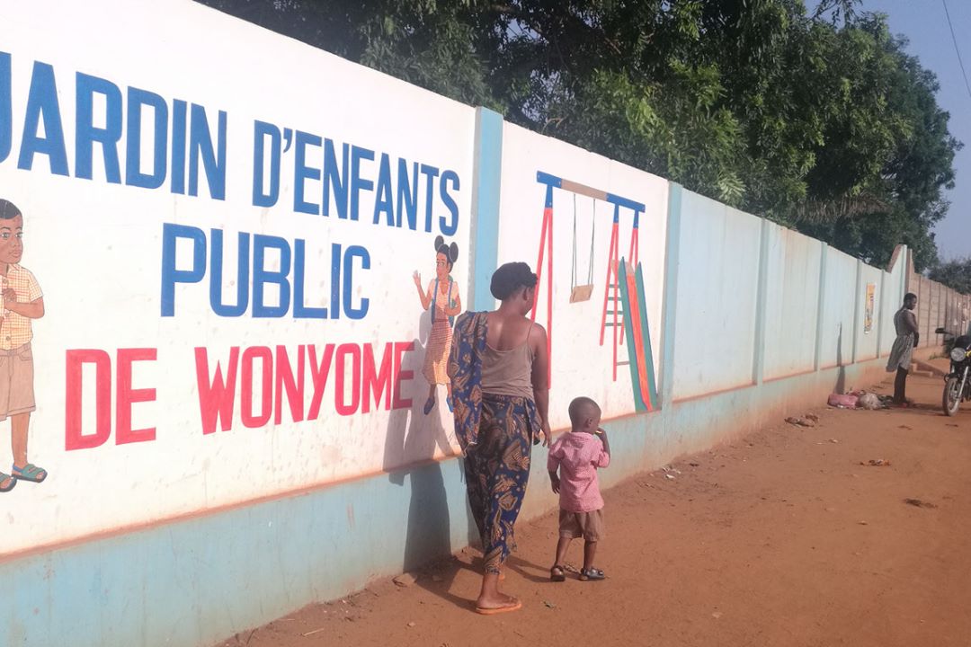 Mme Solim Tchaa et son fils à l’entrée du Jardin d’enfants public de Wonyomé. Crédit : Nephthali Ledy
