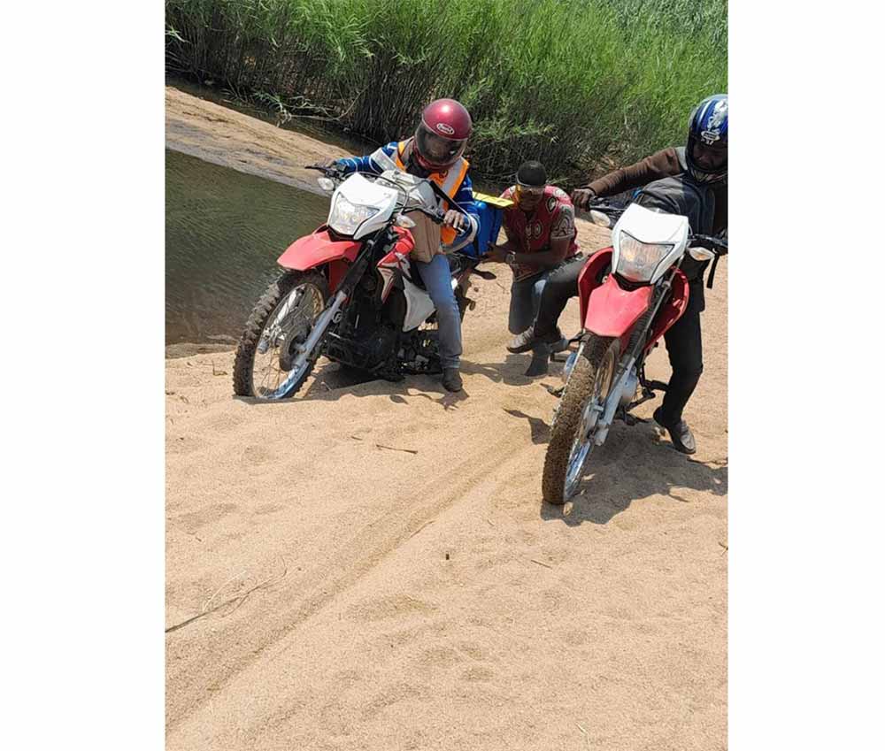 Mozambique's rough terrain presents a challenge to immunization programs. Here, motorcycles carrying coolers of polio vaccines get stuck in the sand. Photo courtesy of Luciana Flannery/CDC