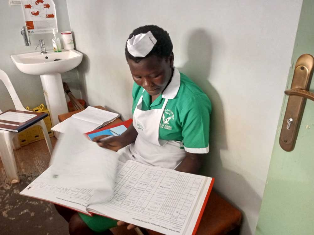 A nurse going through a registration book. Credit: 