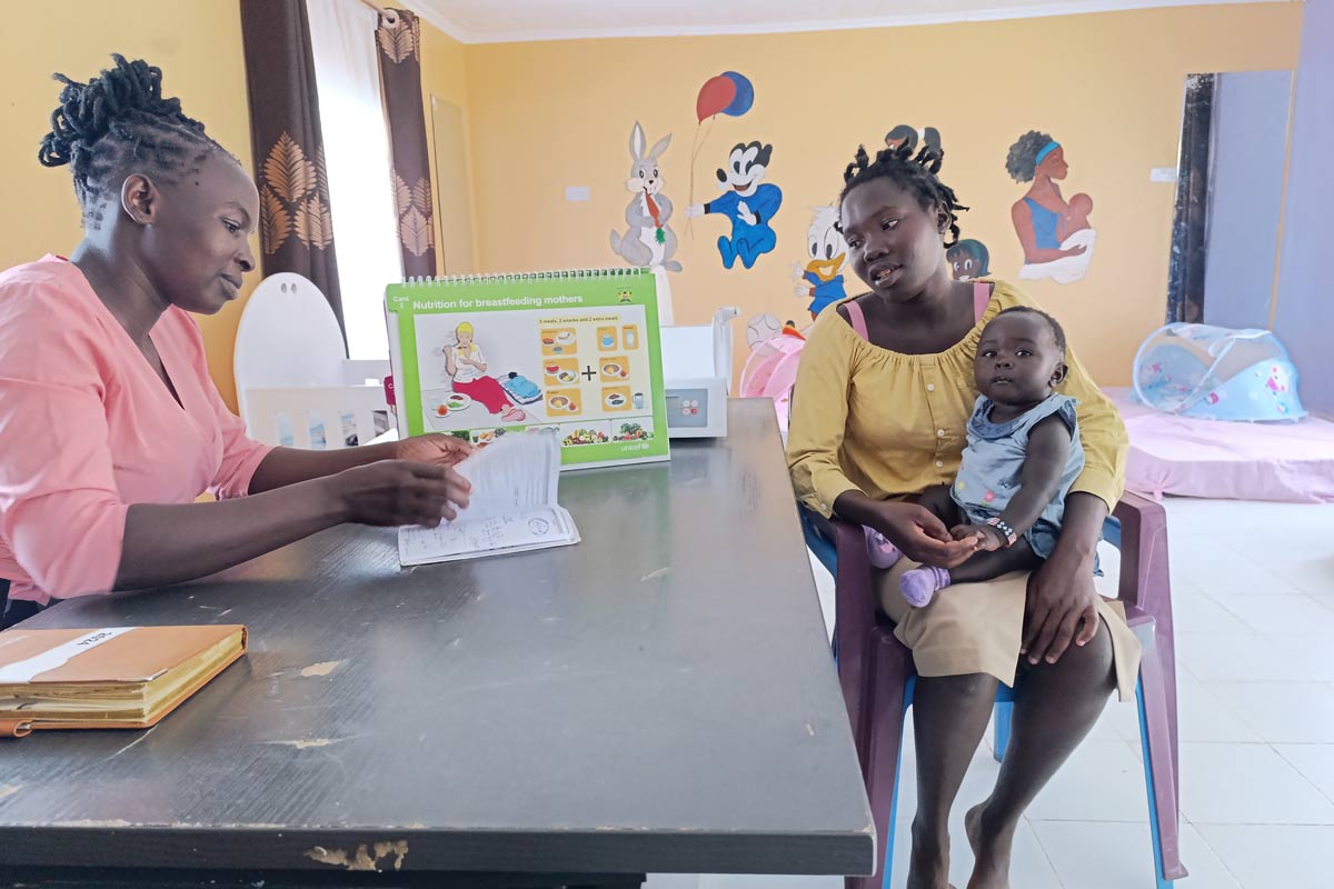 Evaline Awino, a community health expert, goes through Sheila Awuor's clinic book on 24 June 2024. Credit: Angeline Anyango