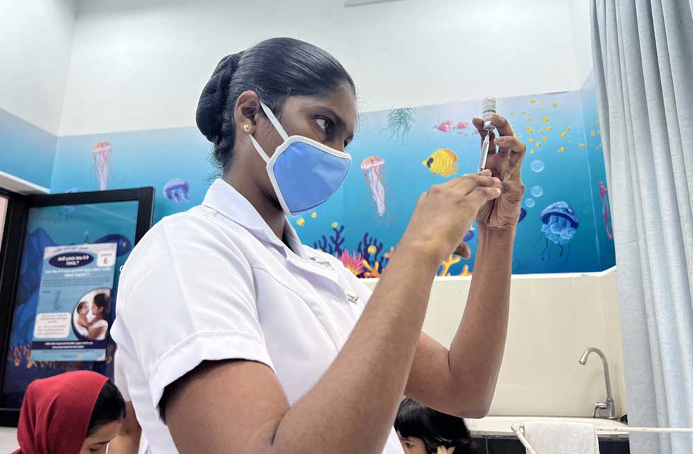 A midwife preparing a vaccine at a Maternal and Child Welfare Center in Colombo