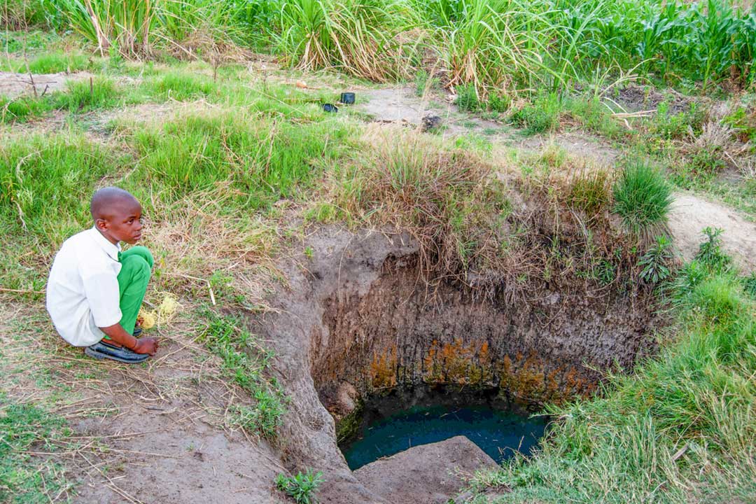 A boy near an unprotected well in Epworth, a dormitory town in the south-eastern part of Harare (Image by Emma Zihonye