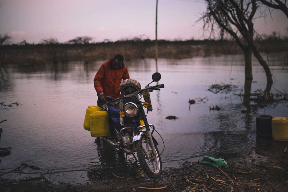 一名年轻人在肯尼亚前东非大裂谷省的巴林戈湖收集家庭用水。