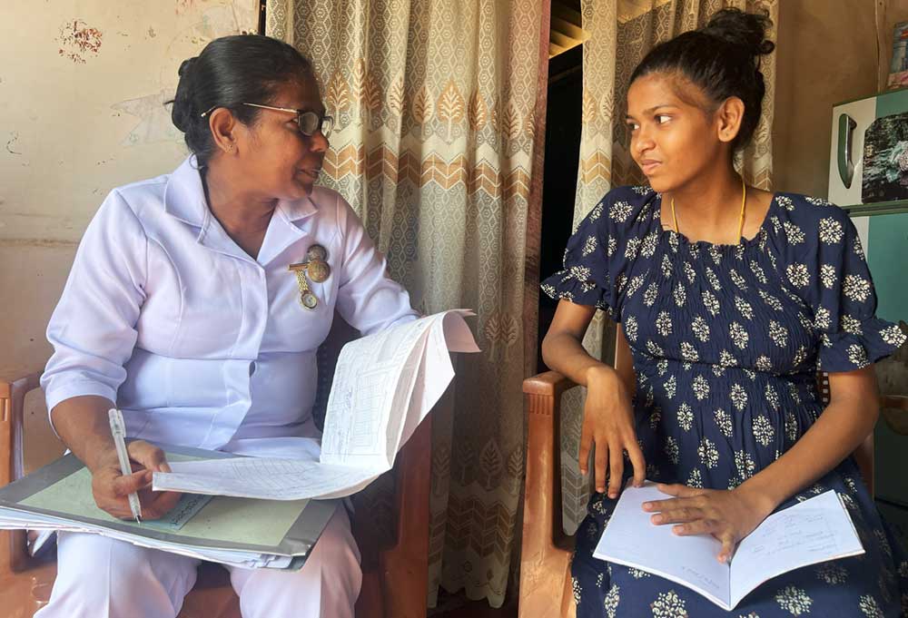 Samanthi Priyangika Dias with a young mother. Teenage pregnancies are high in the area where they work.