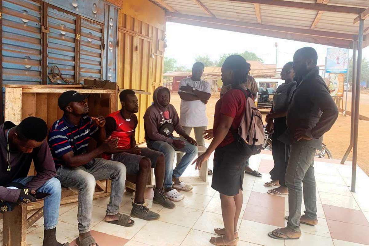 A health care worker (far right) educating a group of men on the importance of immunisation. Credit: JSI
