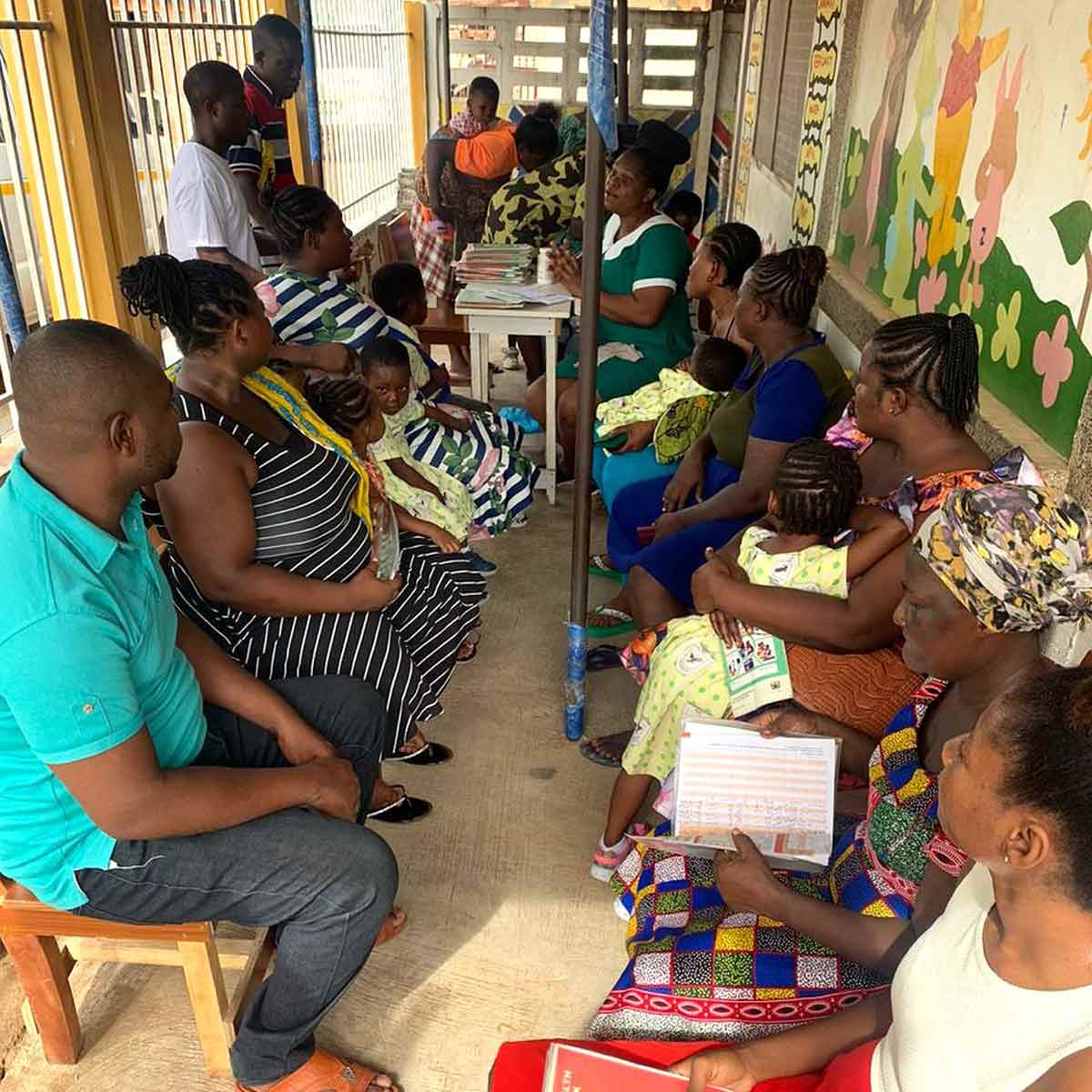 Parents submitting their Maternal and Child Health Booklets to healthcare workers for their children's vaccinations. Credit: JSI