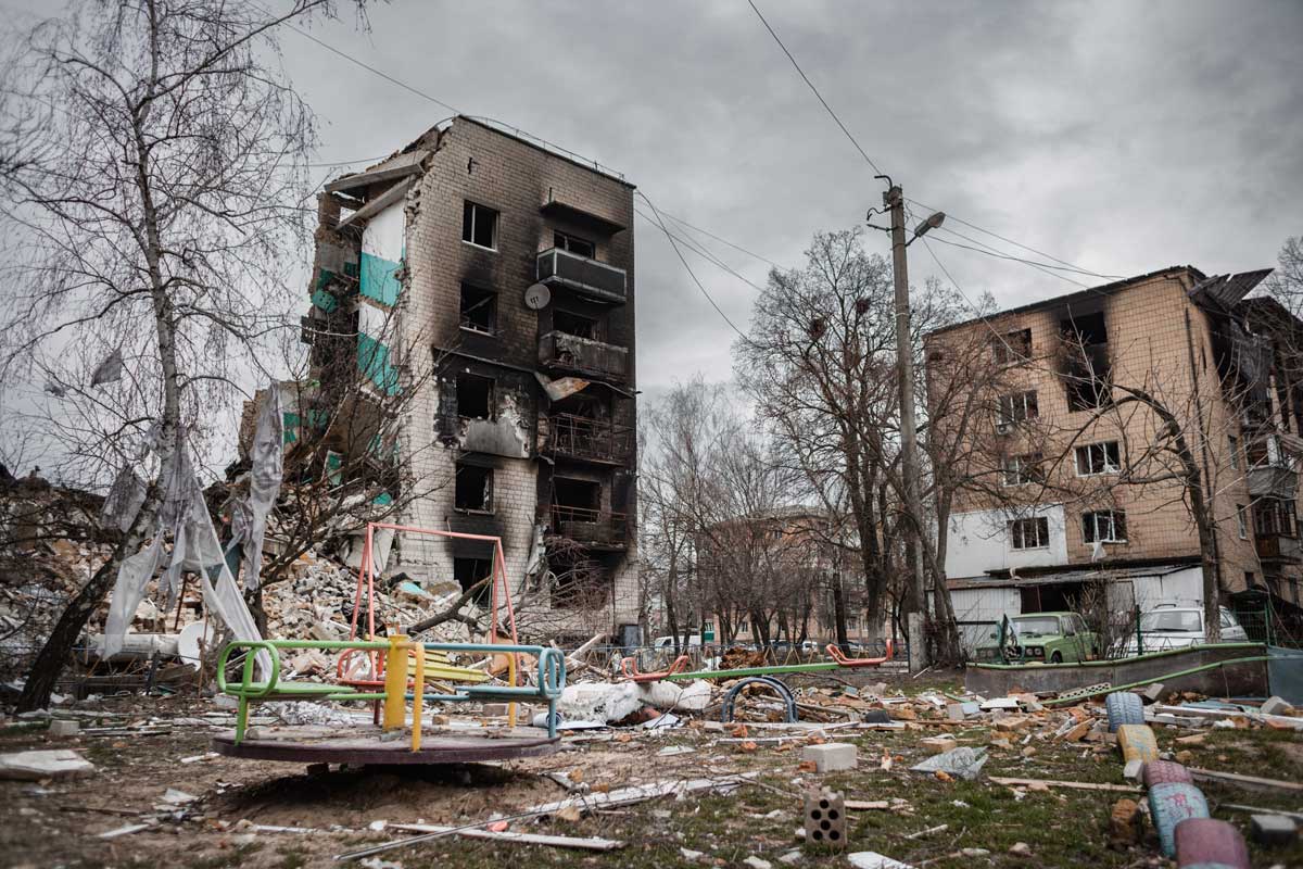 A destroyed house in Borodianka, Ukraine, with a children's play park in front.