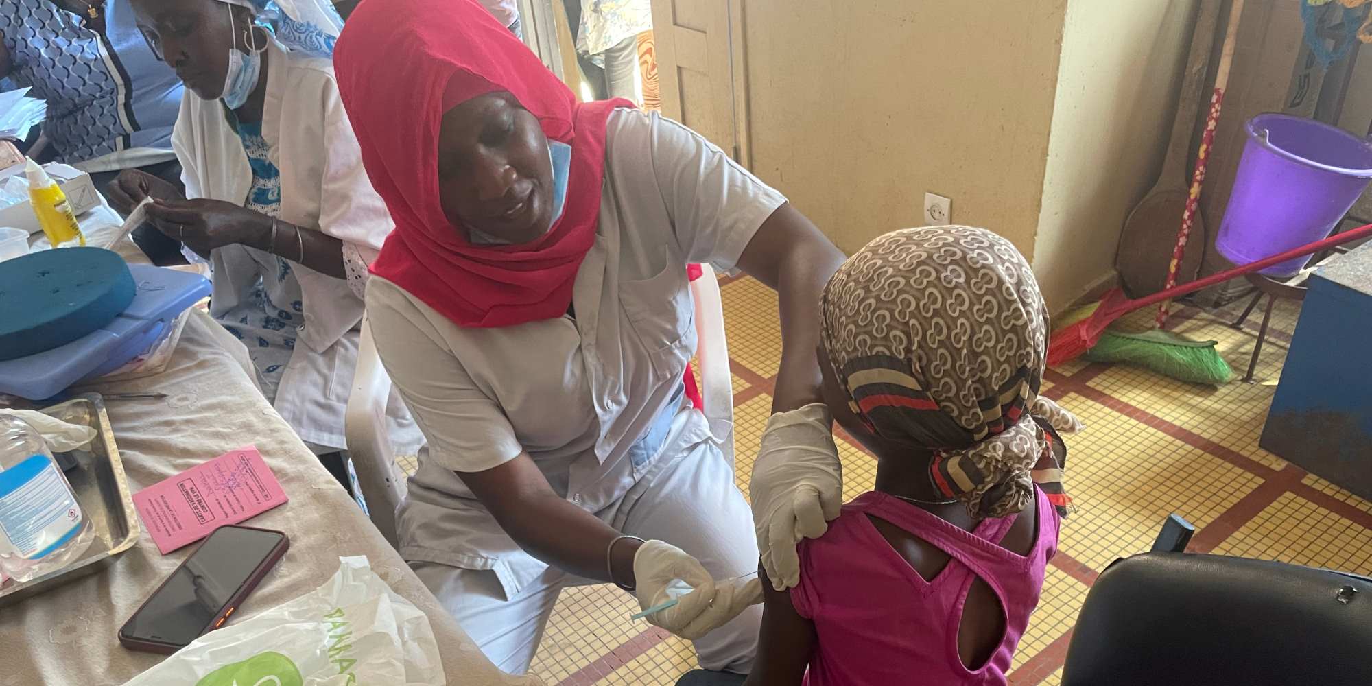 Kady Diaw, infirmière responsable de la vaccination, injecte la première dose du vaccin contre le VPH à une écolière de 9 ans, dans le quartier de Yoff à Dakar. Crédit : Clémence Cluzel