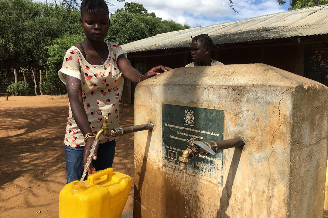 Locals getting water from a solar pump system in Nabilatuk district. Water flows automatically from several taps, meaning users don’t have to queue for long hours. Credit: Pius Sawa