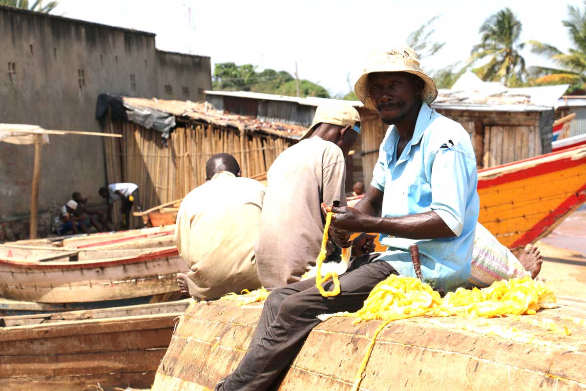 Ladislas Ndikumana while repairing his boat on the shores of lake Tanganyika in Rumonge province. Credit: Moses Havyarimana