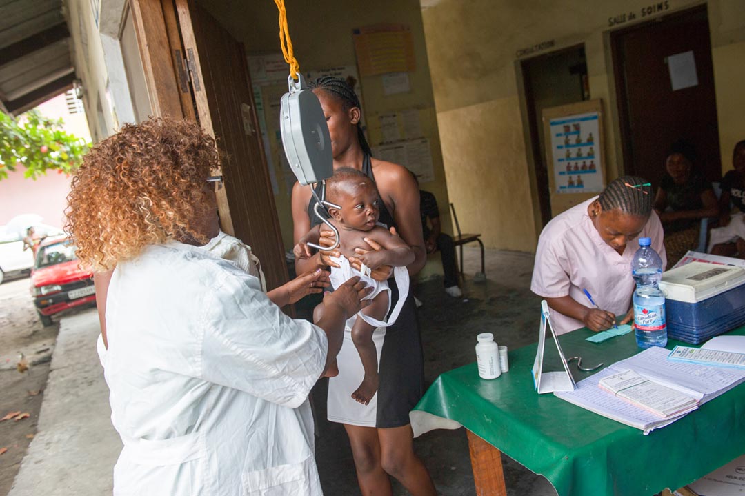 Madelein Semo, a nurse-vaccinator, weighs a young baby prior to vaccination at the Ngbaka health centre in Kinshasa, Democratic Republic of the Congo. Credit: GAVI/2015/Phil Moore