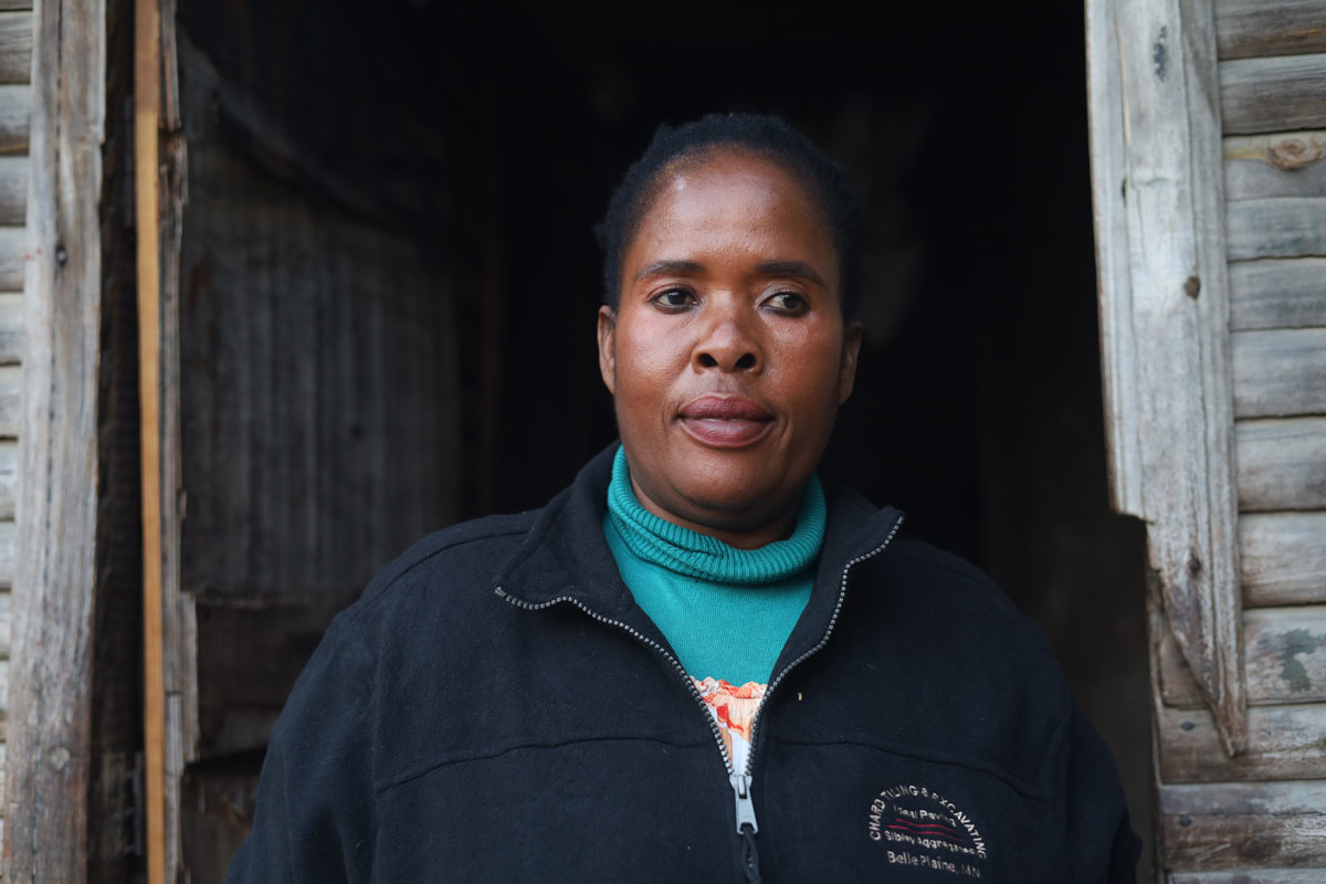 Estella Mufute, who has been living with HIV for the past 23 years, stands at the entrance of her house in Sakubva, Mutare. Credit: Farai Shawn Matiashe/Gavi/2024