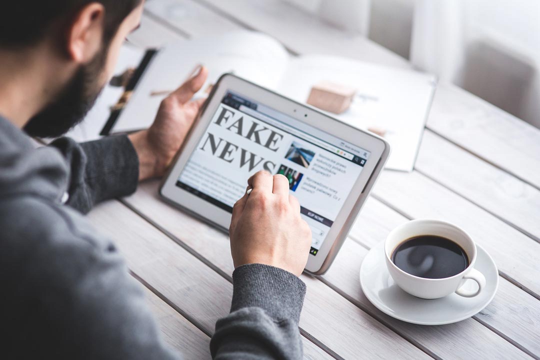 A man reading "fake news" on a tablet. Credit: memyselfaneye from Pixabay