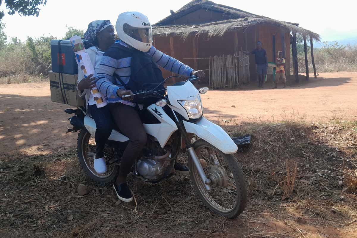 Felix Cardoso spends several hours on a damaged road biking vaccines to the hard to reach communities in Gile District with the help of a village elder for directions. Credit: Charles Mangwiro.