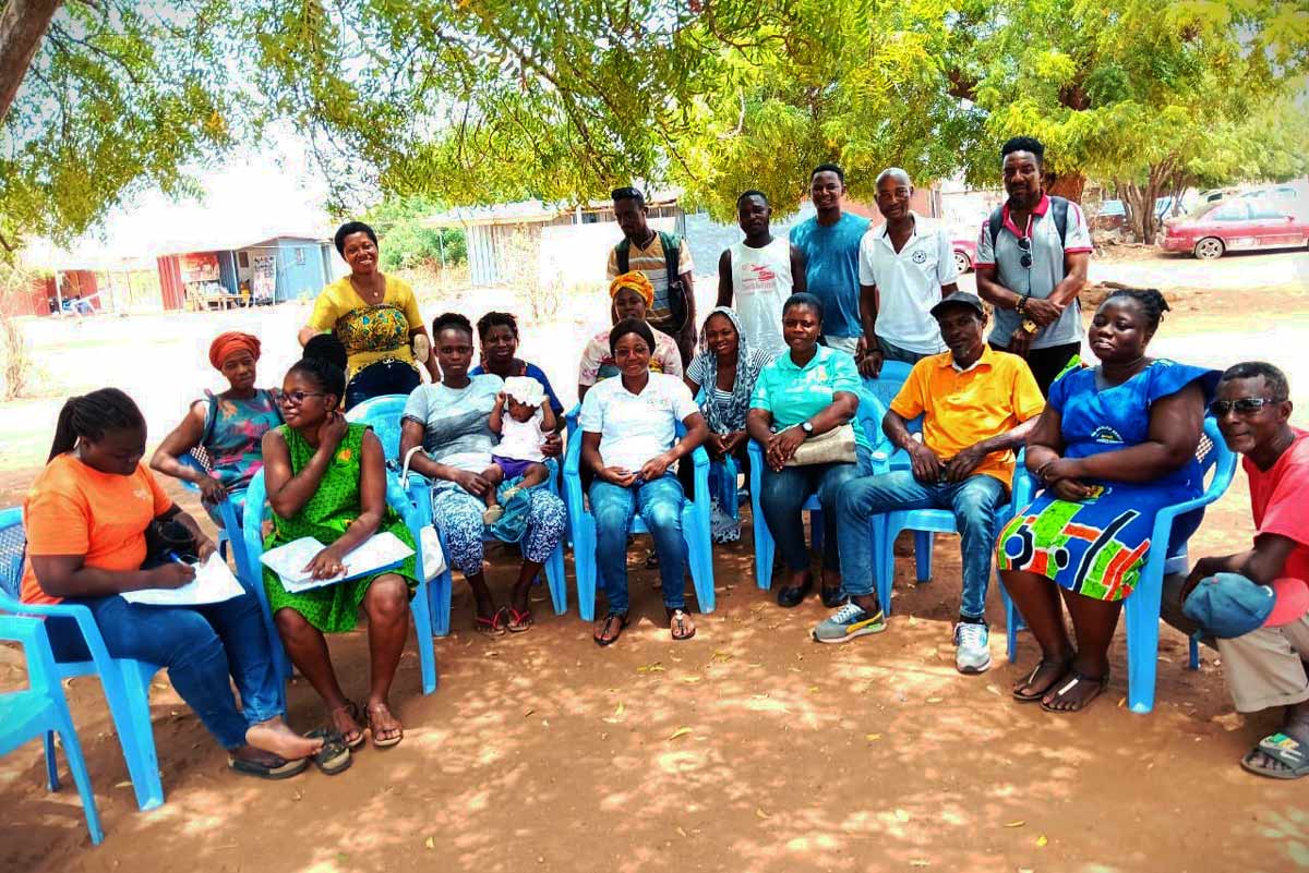 A female nurse (far left) poses with community members after a discussion on the importance of immunisation. Credit: JSI