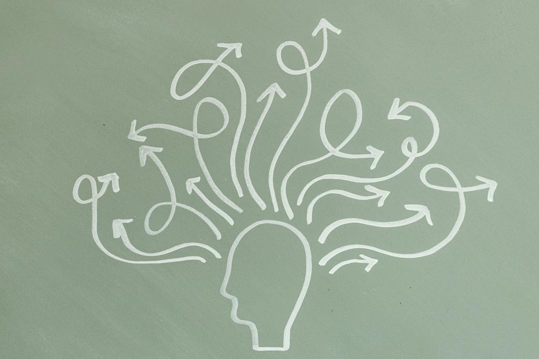 Illustration of a head with "messy" thoughts - arrows going in all directions. Credit: Tara Winstead on Pexels