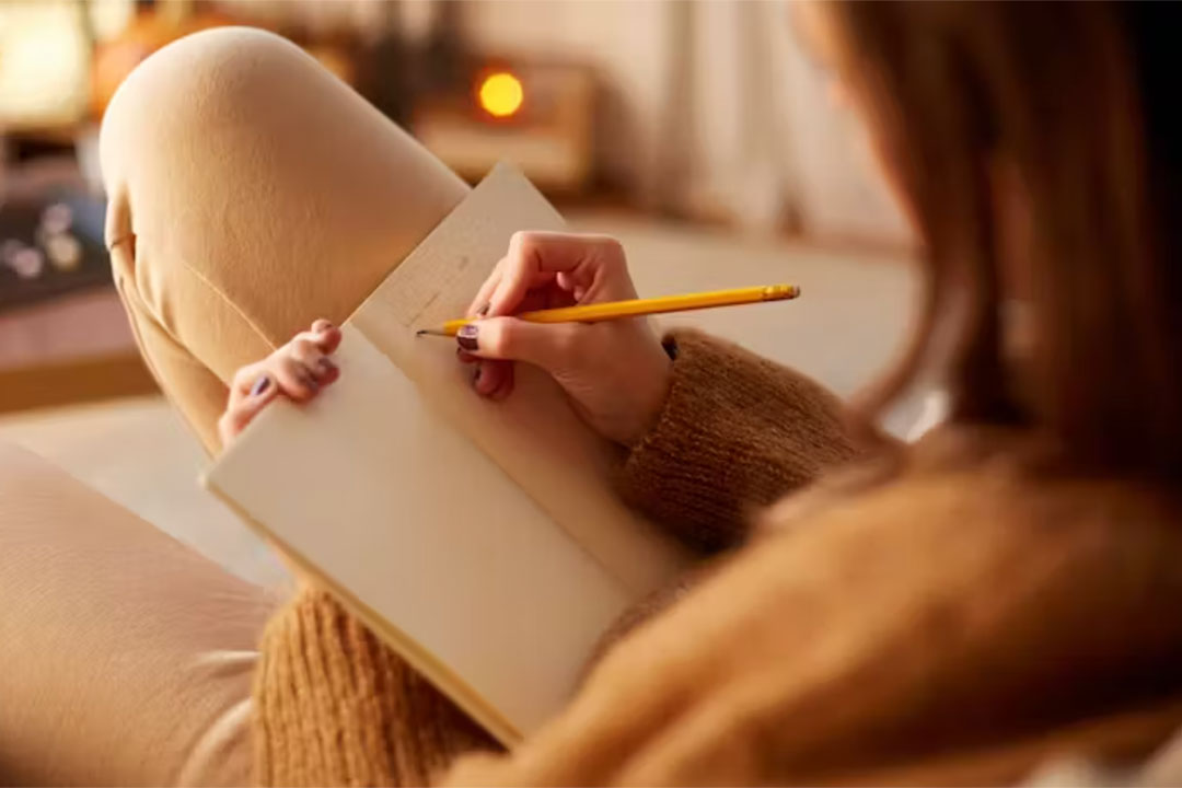 A woman writing in a diary. Credit: Ground Picture/Shutterstock