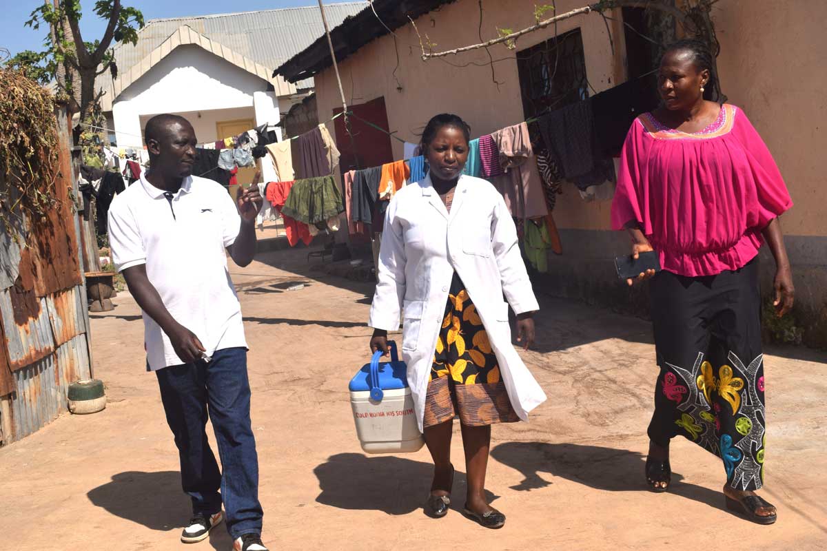 Community leader Michael Nyam Sila (left) walking with nurses to an HPV vaccination point. Credit: Richard Adupong, JSI
