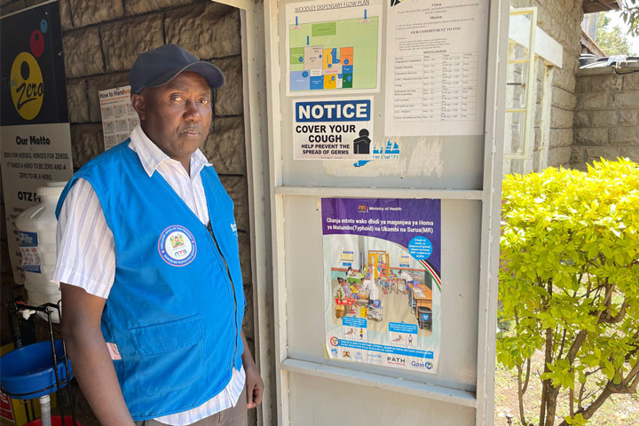 Community Health Worker Christopher Osuto showing a poster in Kibera. Credit: Pauline Tom