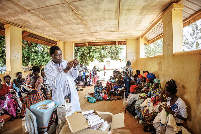 Dr Ogwal Daniel attends to mothers and children during an immunisation day at Ibuje Health Centre in Apac